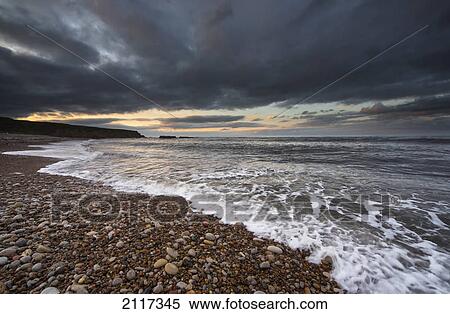 Water coming up on the shore under storm clouds; sunderland tyne and wear england View Large Photo Image Stock Photography - Water coming up on the shore under storm clouds; sunderland tyne and wear england. Fotosearch