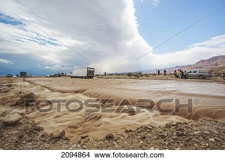 Picture - Water flowing over a washed out road after a flood; jordan valley israel. Fotosearch