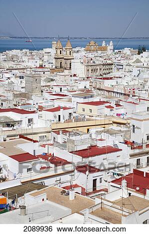 Stock Photograph - Whitewashed buildings in a town on the coast; cadiz, andalusia, spain. Fotosearch