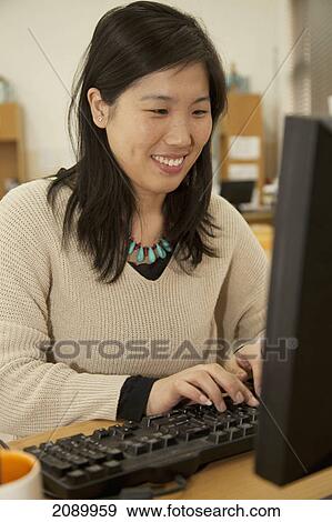 Woman working at a computer on a desk; beijing, china View Large Photo Image Stock Photo - Woman working at a computer on a desk; beijing, china. Fotosearch