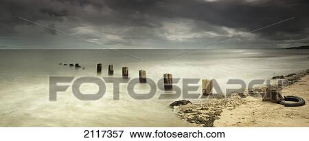 Wooden posts submerged in the water off a beach; berwick northumberland england View Large Photo Image Stock Photo - Wooden posts submerged in the water off a beach; berwick northumberland england. Fotosearch