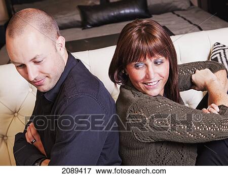 Young couple back to back making amends after a fight; edmonton, alberta, canada View Large Photo Image Stock Photo - Young couple back to back making amends after a fight; edmonton, alberta, canada. Fotosearch