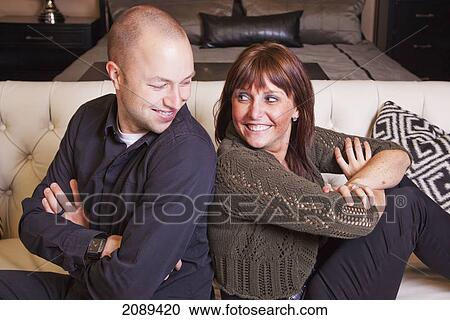 Stock Image - Young couple back to back pretending to fight; edmonton, alberta, canada. Fotosearch