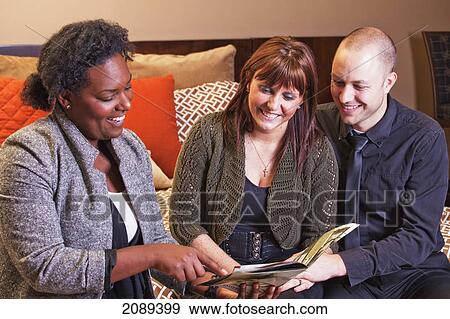 Stock Photo - Young couple shopping for furniture with an interior design consultant; edmonton, alberta, canada. Fotosearch
