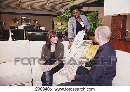 Stock Photography - Young couple shopping for furniture with interior design consultant; edmonton, alberta, canada. Fotosearch