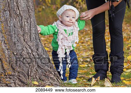 Stock Photo - Young mother with baby daughter in a park in autumn; edmonton, alberta, canada. Fotosearch
