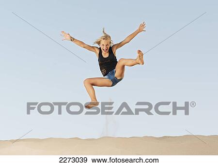 Stock Photo - A girl jumping on the beach; tarifa cadiz andalusia spain. Fotosearch