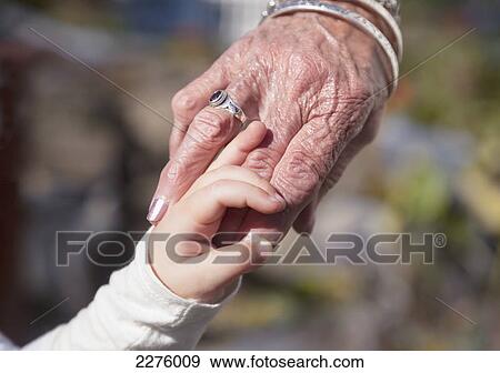 A granddaughter holds the hand of her great-grandmother; british columbia canada View Large Photo Image Stock Photo - A granddaughter holds the hand of her great-grandmother; british columbia canada. Fotosearch