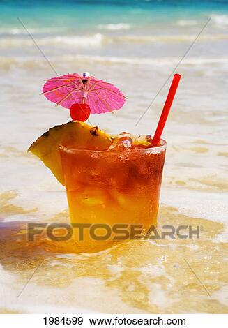 A Mai Tai Garnished With Pinapple And A Cherry, Sitting In Shallow Water On The Beach. View Large Photo Image Stock Photo - A Mai Tai Garnished With Pinapple And A Cherry, Sitting In Shallow Water On The Beach.. Fotosearch