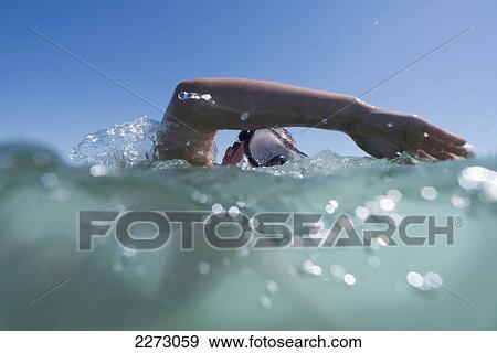 Stock Photo - A person swimming with goggles on the surface of the water; tarifa cadiz andalusia spain. Fotosearch