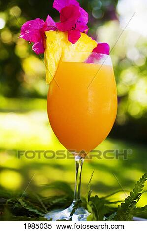 A Tropical Cocktail Garnished With Fruit In An Outdoor Setting. View Large Photo Image Stock Photography - A Tropical Cocktail Garnished With Fruit In An Outdoor Setting.. Fotosearch