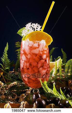 Stock Photo - A Tropical Drink Garnished With Fruit And Flowers.. Fotosearch