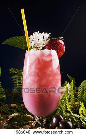 A Tropical Drink Garnished With Fruit And Flowers. View Large Photo Image Stock Photo - A Tropical Drink Garnished With Fruit And Flowers.. Fotosearch