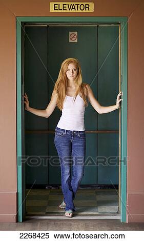 Stock Photography - A young woman stands in the open doors of an elevator; kauai hawaii united states of america. Fotosearch