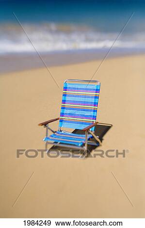 Brightly Colored Beach Chair On The Sand Near The Ocean. View Large Photo Image Stock Photo - Brightly Colored Beach Chair On The Sand Near The Ocean.. Fotosearch