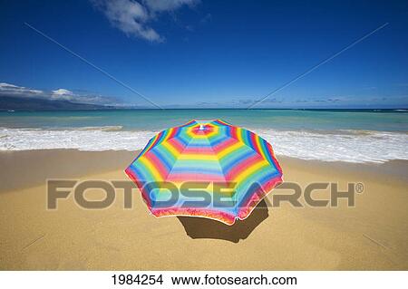 Picture - Brightly Colored Beach Umbrella On The Sand Near The Ocean.. Fotosearch