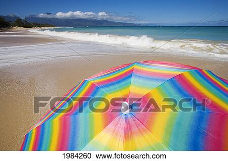 Brightly Colored Beach Umbrella On The Sand Near The Ocean. View Large Photo Image Stock Image - Brightly Colored Beach Umbrella On The Sand Near The Ocean.. Fotosearch
