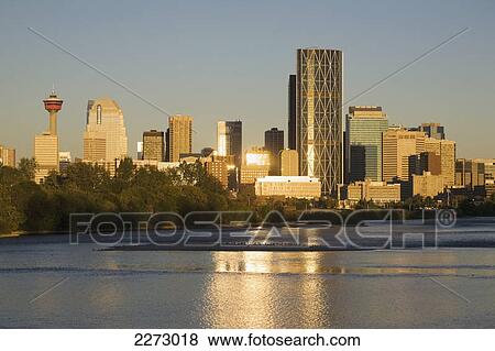 Stock Photo - Calgary cityscape along river with reflections on building and river at sunrise with blue sky; calgary alberta canada. Fotosearch