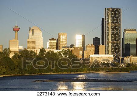 Calgary cityscape along river with reflections on building and river at sunrise with blue sky; calgary alberta canada View Large Photo Image Stock Photo - Calgary cityscape along river with reflections on building and river at sunrise with blue sky; calgary alberta canada. Fotosearch