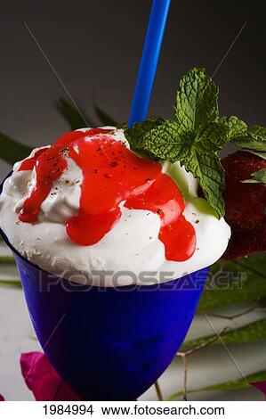 Close-Up Of A Blue Cocktail Glass Filled With A Creamy Tropical Drink Dripping With Strawberry Syrup. View Large Photo Image Picture - Close-Up Of A Blue Cocktail Glass Filled With A Creamy Tropical Drink Dripping With Strawberry Syrup.. Fotosearch