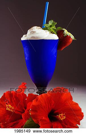 Stock Photo - Close-Up Of A Blue Cocktail Glass Filled With A Creamy Tropical Drink, Garnished With Strawberry And Mint.. Fotosearch