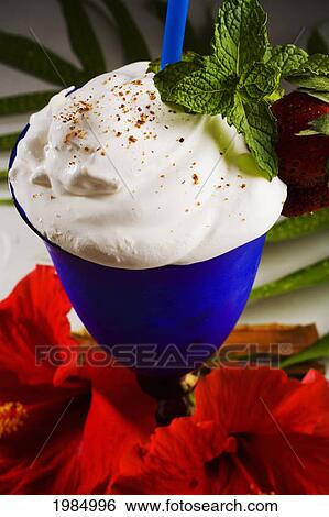 Stock Photograph - Close-Up Of A Blue Cocktail Glass Filled With A Creamy Tropical Drink, Garnished With A Sprig Of Mint.. Fotosearch