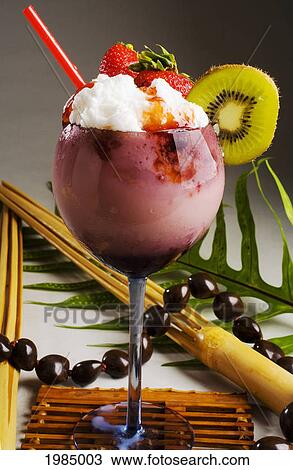 Stock Image - Close-Up Of A Cocktail Glass Filled With A Creamy Pink Tropical Drink Dripping With Strawberry Syrup.. Fotosearch