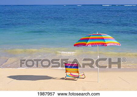 Stock Photo - Colorful Beach Chair And Umbrella On The Shoreline Of A Tropical Beach, Calm Waves Washing Ashore, Turquoise Water.. Fotosearch