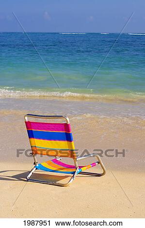 Colorful Beach Chair On The Shoreline Of A Tropical Beach, Calm Waves Washing Ashore, Turquoise Water. View Large Photo Image Stock Image - Colorful Beach Chair On The Shoreline Of A Tropical Beach, Calm Waves Washing Ashore, Turquoise Water.. Fotosearch