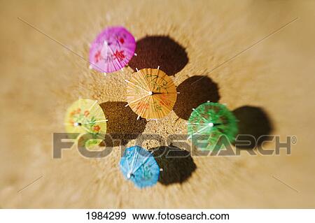 Colorful Cocktail Umbrellas Stuck In The Sand Of A Tropical Beach. View Large Photo Image Stock Photo - Colorful Cocktail Umbrellas Stuck In The Sand Of A Tropical Beach.. Fotosearch