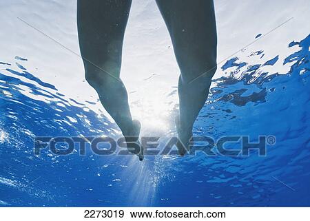 Stock Photo - Legs swimming in a pool with sunlight shining through the water; tarifa cadiz andalusia spain. Fotosearch