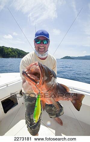 Stock Image - Man holds cubera snapper (lutjanus cyanopterus); panama. Fotosearch