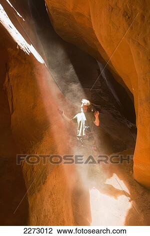 Man looking up into a sunbeam streaming into a slot-canyon; san rafael swell utah united states of america View Large Photo Image Stock Image - Man looking up into a sunbeam streaming into a slot-canyon; san rafael swell utah united states of america. Fotosearch