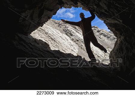 Man posing in a cave entrance; coleman alberta canada View Large Photo Image Stock Photo - Man posing in a cave entrance; coleman alberta canada. Fotosearch