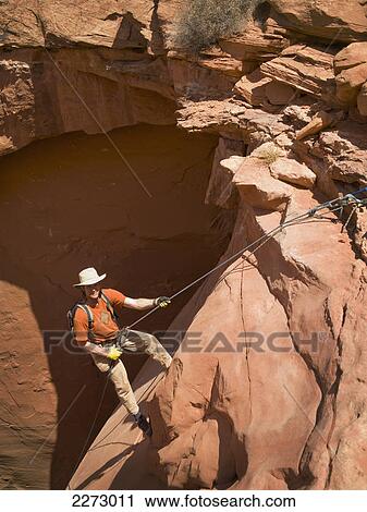 Stock Image - Man rappelling into a canyon; san rafael swell utah united states of america. Fotosearch