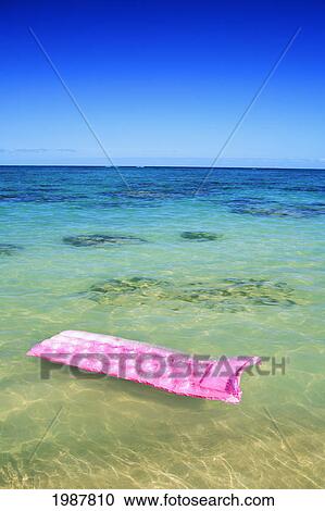 Stock Image - Pink Inflated Raft On Clear Ocean Water.. Fotosearch