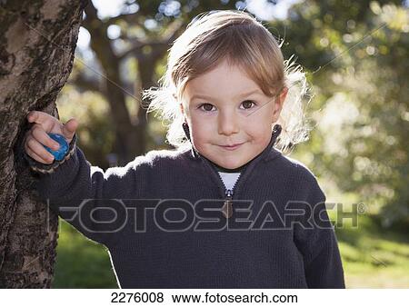 Portrait of a young boy standing beside an apple tree; british columbia canada View Large Photo Image Stock Photo - Portrait of a young boy standing beside an apple tree; british columbia canada. Fotosearch