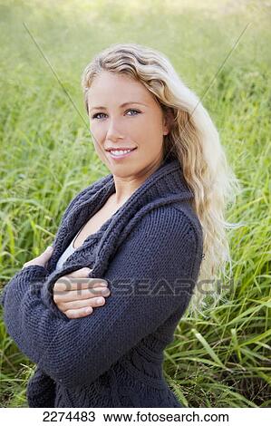 Portrait of a young woman standing in a grass field; hawaii united states of america View Large Photo Image Stock Image - Portrait of a young woman standing in a grass field; hawaii united states of america. Fotosearch
