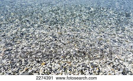 Stock Image - Rocks seen through clear water in kastani bay; skopelos island greece. Fotosearch