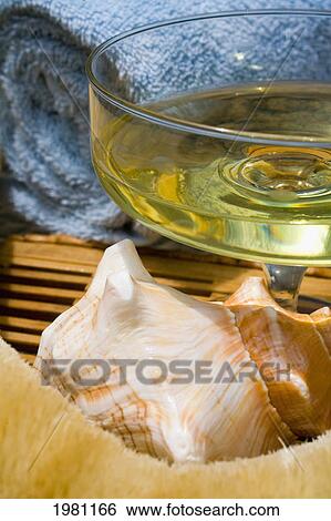Spa Elements, Glass Filled With Yellow Liquid, With Seashell, Towel And Natural Loofah. View Large Photo Image Stock Photograph - Spa Elements, Glass Filled With Yellow Liquid, With Seashell, Towel And Natural Loofah.. Fotosearch