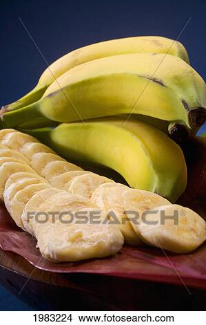 Studio Shot Of Bananas, Whole And Cut Into Slices, With Flowers. View Large Photo Image Picture - Studio Shot Of Bananas, Whole And Cut Into Slices, With Flowers.. Fotosearch