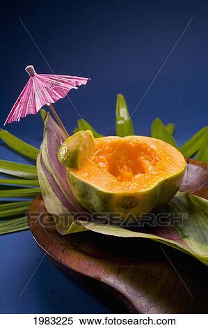 Stock Photography - Studio Shot Of Half Of A Papaya, Seeds Removed, With Cocktail Umbrella.. Fotosearch