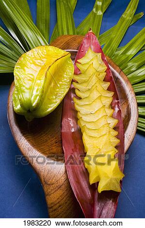 Stock Image - Studio Shot Of Starfruit, Whole And Cut Into Slices, With Flowers.. Fotosearch