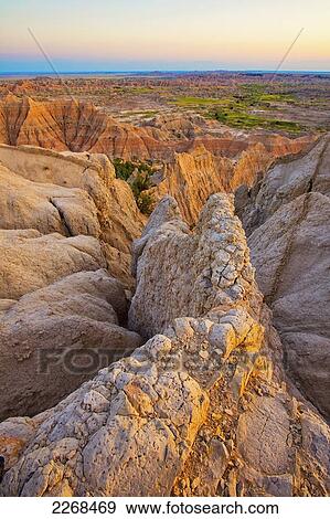 The setting sun lights up the formations in badlands national park as seen from the pinnacles lookout; south dakota united states of america View Large Photo Image Stock Photo - The setting sun lights up the formations in badlands national park as seen from the pinnacles lookout; south dakota united states of america. Fotosearch