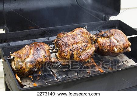 Three whole chickens golden brown on a bbq rotisserie with flames; calgary alberta canada View Large Photo Image Stock Image - Three whole chickens golden brown on a bbq rotisserie with flames; calgary alberta canada. Fotosearch