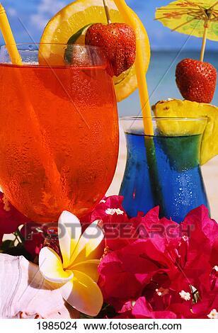 Picture - Tropical Cocktails Garnished With Flowers And Fruit On The Beach.. Fotosearch