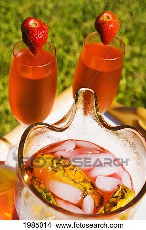 Picture - Two Glasses Next To A Pitcher Filled With A Tropical Drink.. Fotosearch