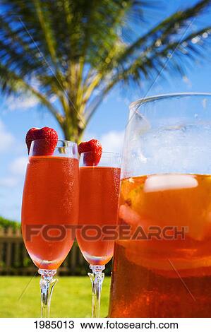 Two Glasses Next To A Pitcher Filled With A Tropical Drink. View Large Photo Image Stock Image - Two Glasses Next To A Pitcher Filled With A Tropical Drink.. Fotosearch