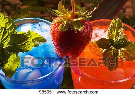 Two Tropical Drinks Garnished With Fruit And Flowers. View Large Photo Image Stock Image - Two Tropical Drinks Garnished With Fruit And Flowers.. Fotosearch