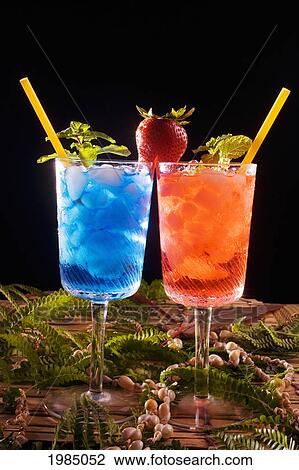 Two Tropical Drinks Garnished With Fruit And Flowers. View Large Photo Image Stock Image - Two Tropical Drinks Garnished With Fruit And Flowers.. Fotosearch